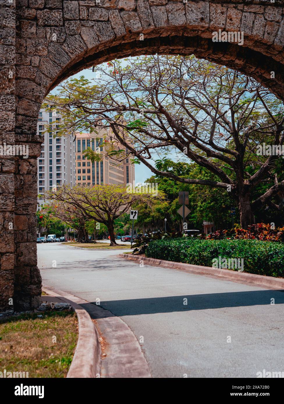 Un arco che incornicia un parco verde in una giornata di sole Foto Stock