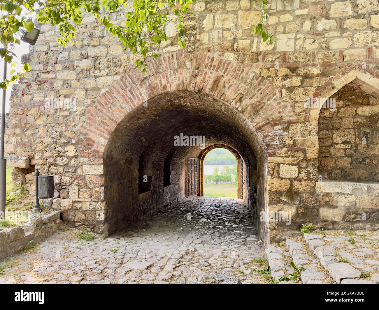 Due porte ad arco che si aprono su uno storico sentiero in mattoni Foto Stock