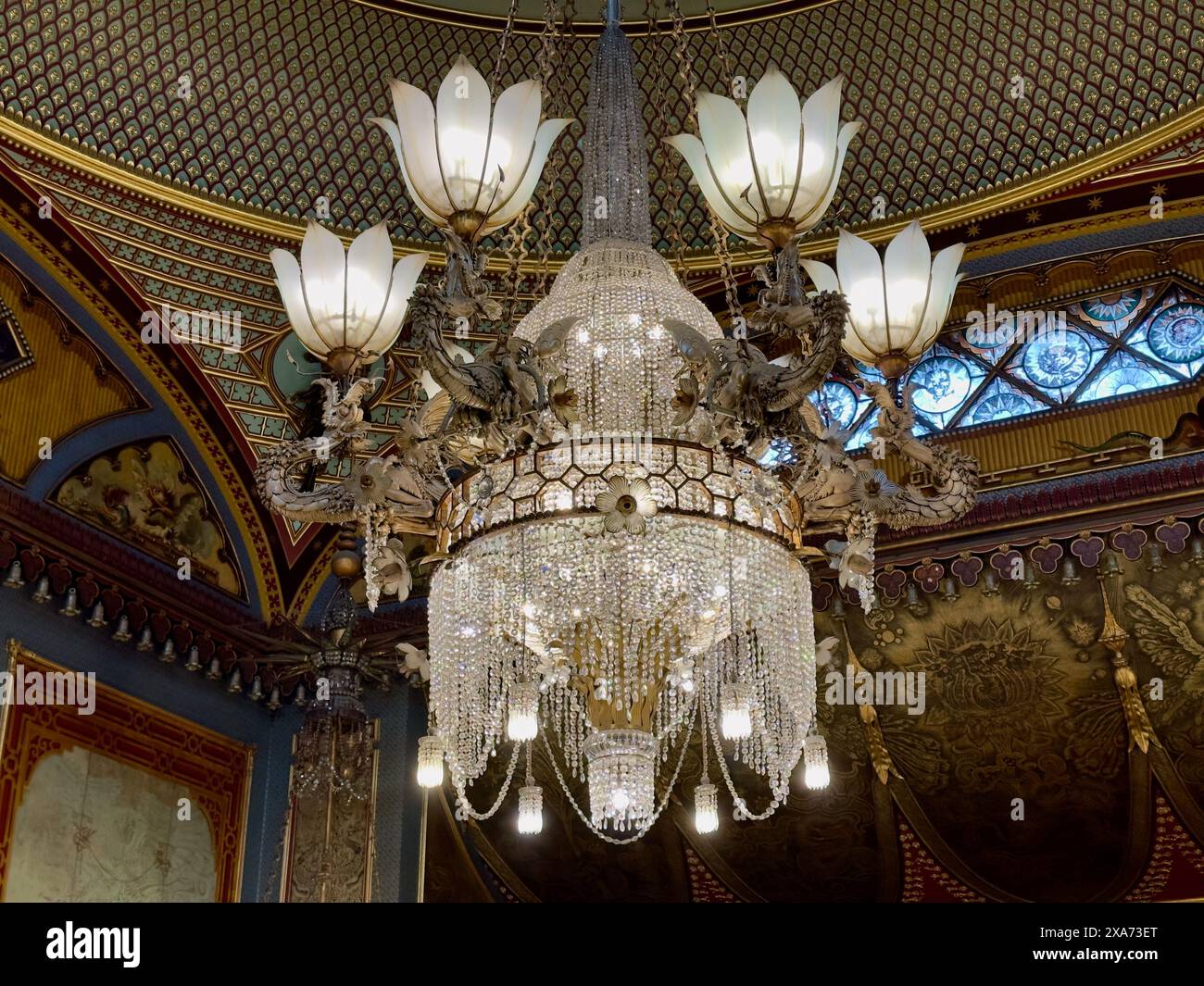 Un elegante lampadario sospeso da un alto soffitto in una camera spaziosa Foto Stock