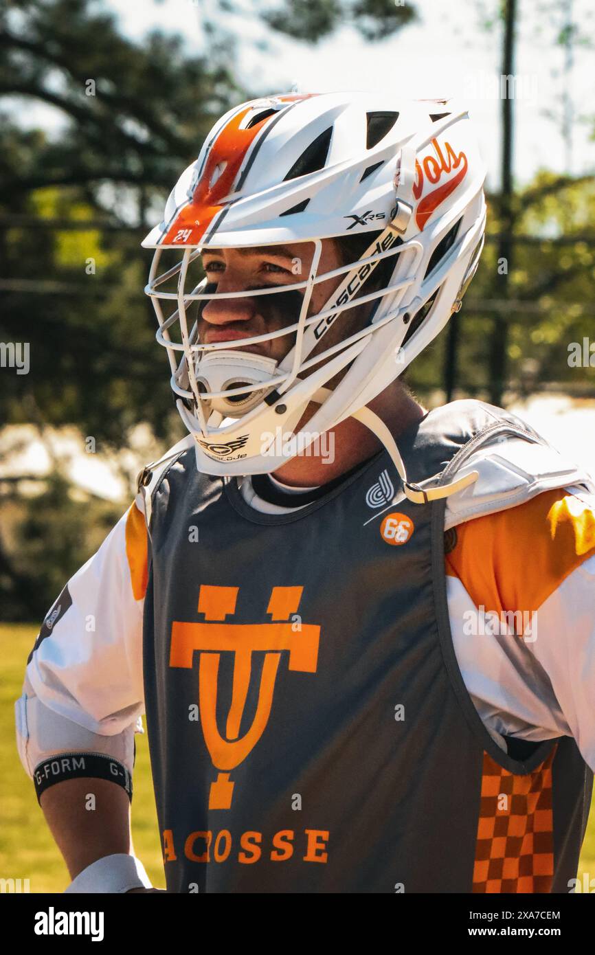 Un uomo che indossa un casco e occhiali protettivi che cammina in un vasto campo Foto Stock