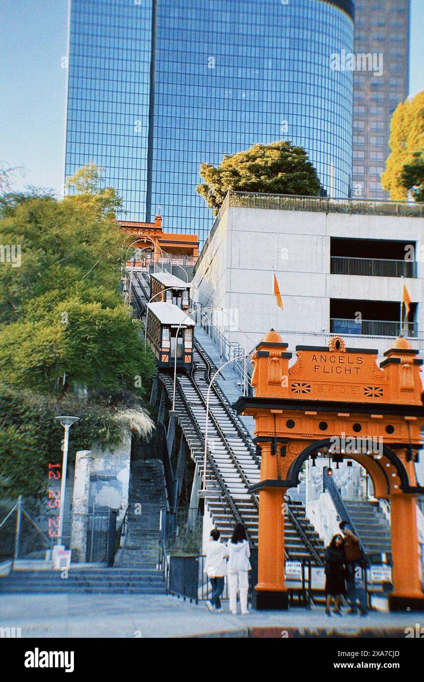 Un gruppo di individui in un'area urbana con treni visibili Foto Stock