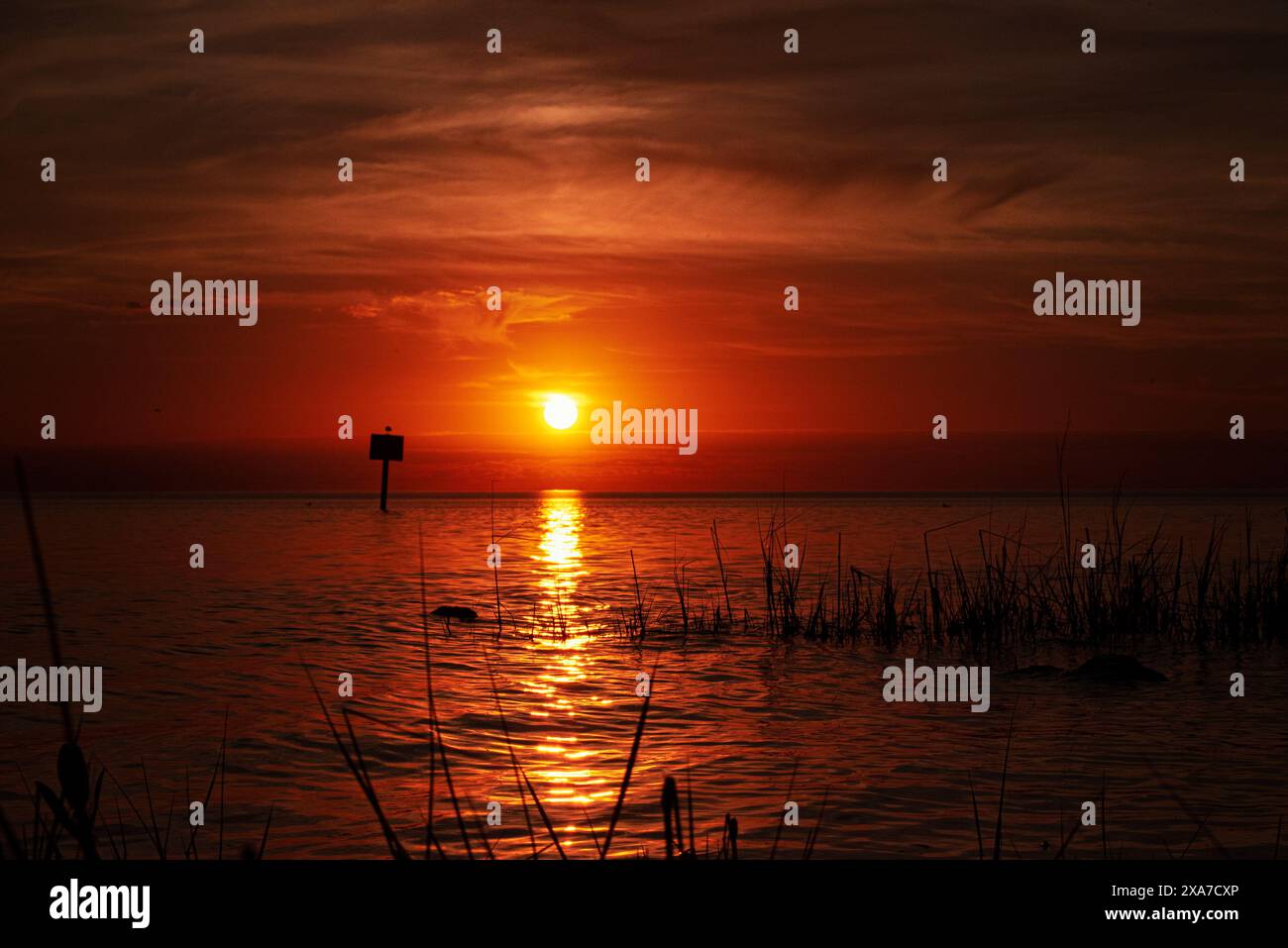 Tramonto sull'acqua tranquilla del lago al tramonto Foto Stock