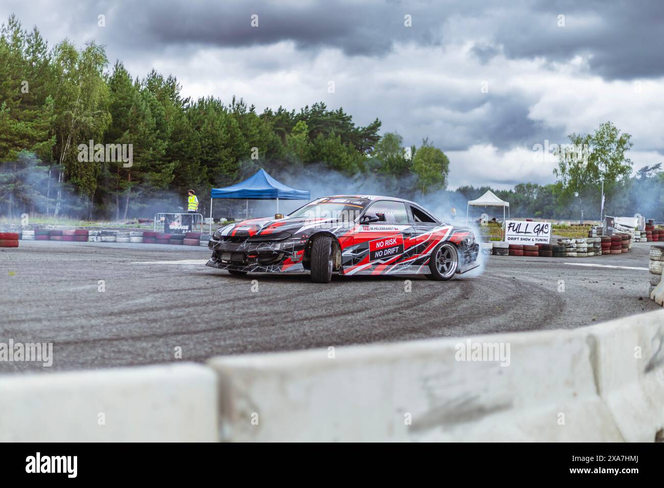 Un'auto da drift che esegue un burnout su una pista da corsa, con fumo emesso dalla vettura Foto Stock