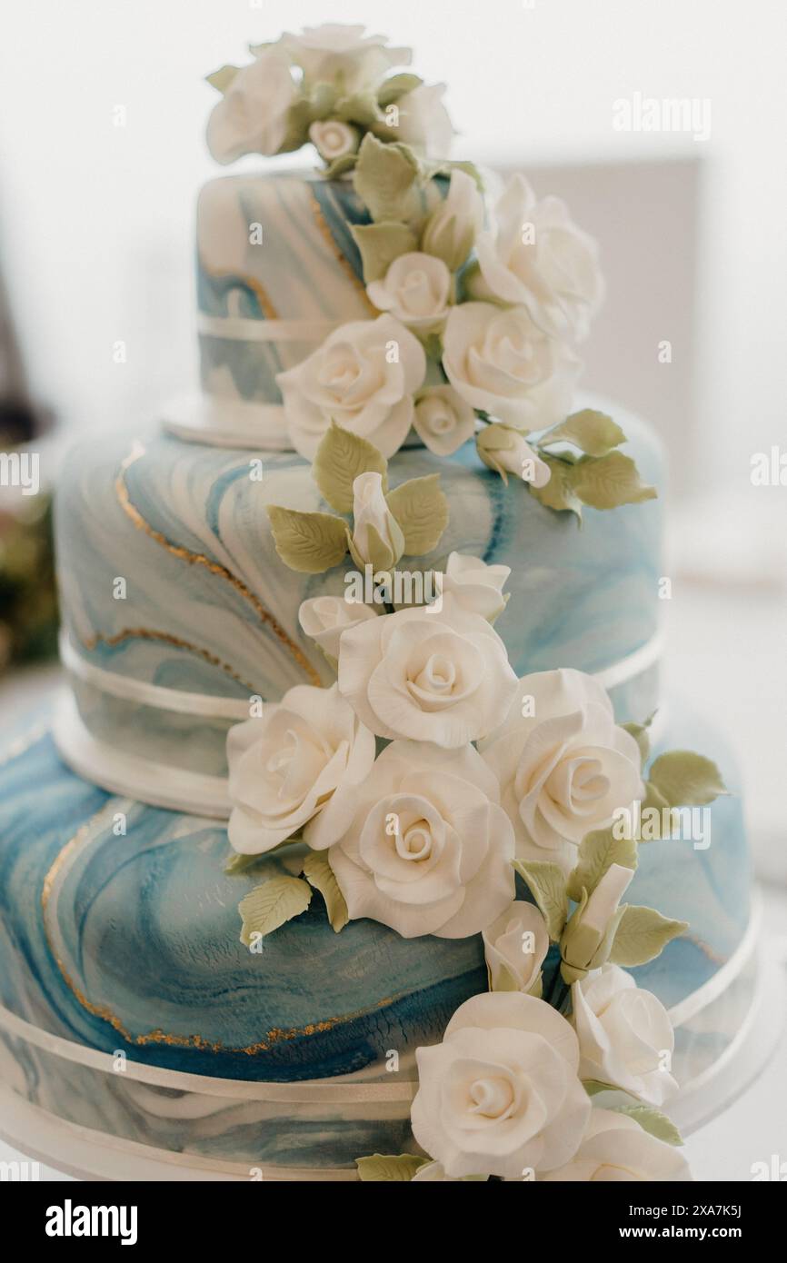 Torta nuziale a tre piani dal design elegante e decorata con motivi floreali Foto Stock