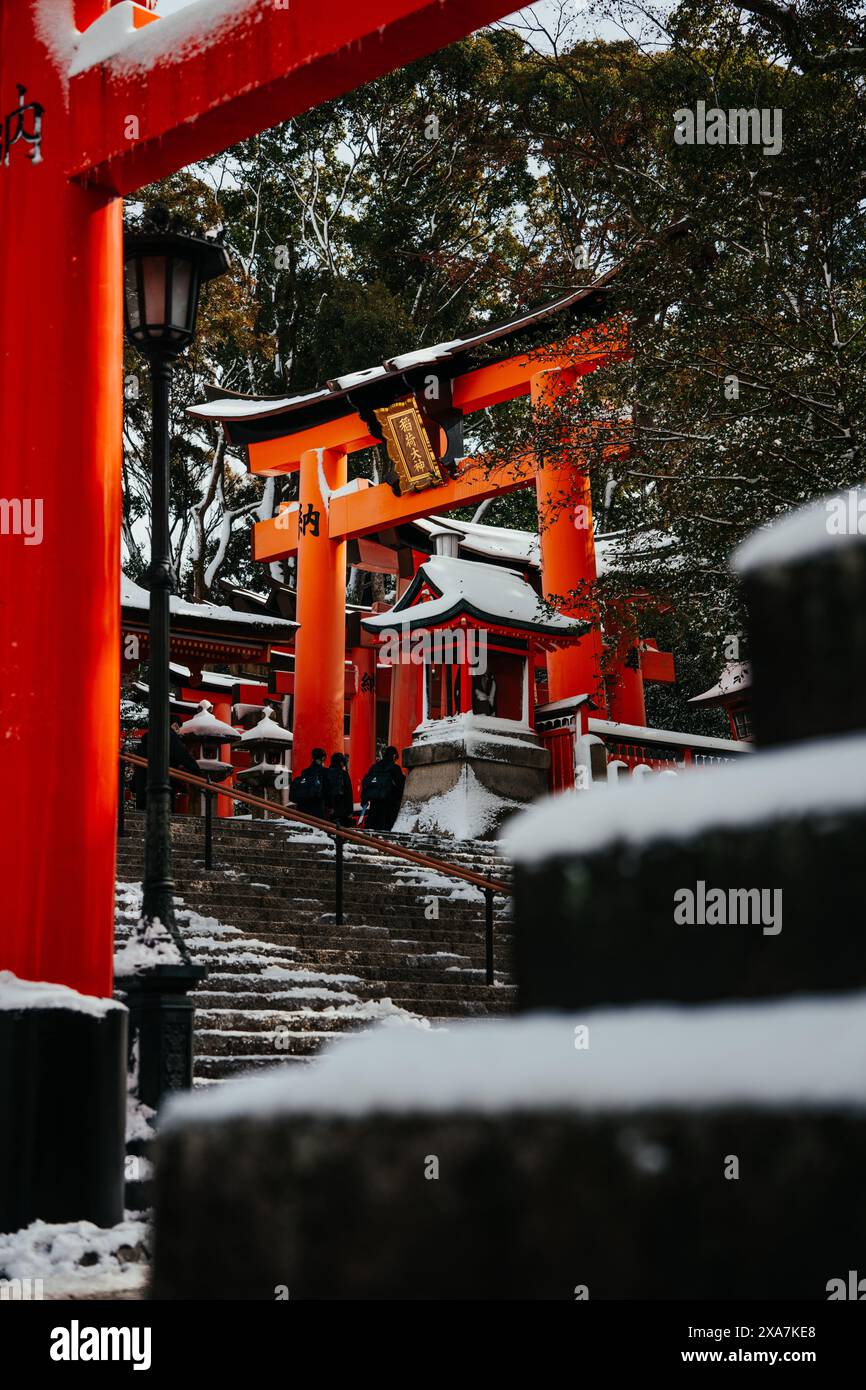 Un'antica porta tradizionale giapponese e templi ricoperti di rare nevicate invernali al Santuario di Fushimi Inari a Kyoto in Giappone. Foto Stock
