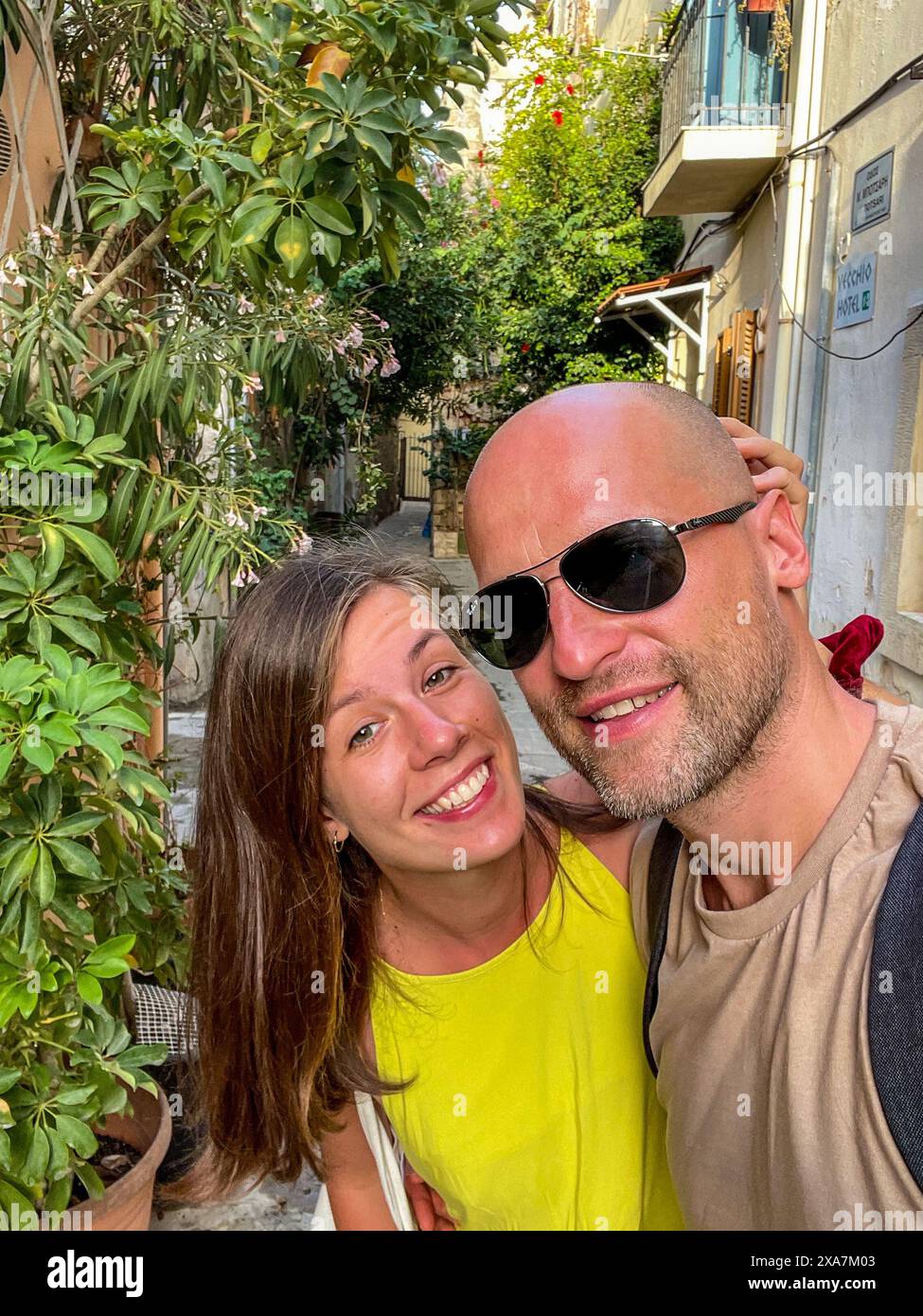 Un uomo barbuto sta accanto a una donna in cima gialla in Grecia Foto Stock