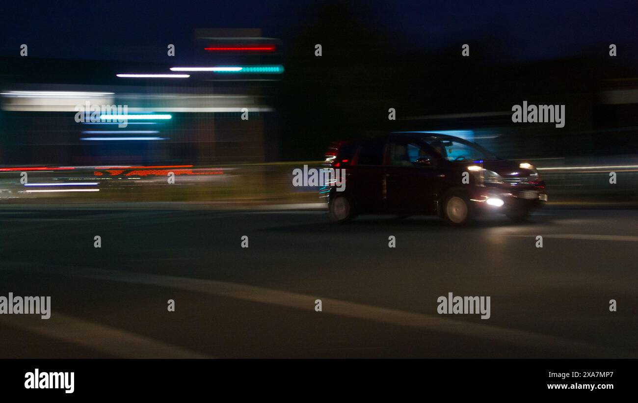 Mostrare le auto e il traffico di notte, utilizzando la panoramica della telecamera per mostrare il movimento dell'auto con le piste leggere. Ad Auckland, nuova Zelanda. Foto Stock