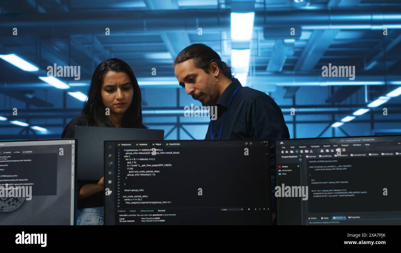 Sviluppatore nell'hub server che utilizza il laptop per presentare il piano di riparazione delle apparecchiature che memorizzano i set di dati. Lo specialista utilizza il notebook per spiegare i modi in cui i leader dei team possono riparare i sistemi che eseguono operazioni computazionali Foto Stock