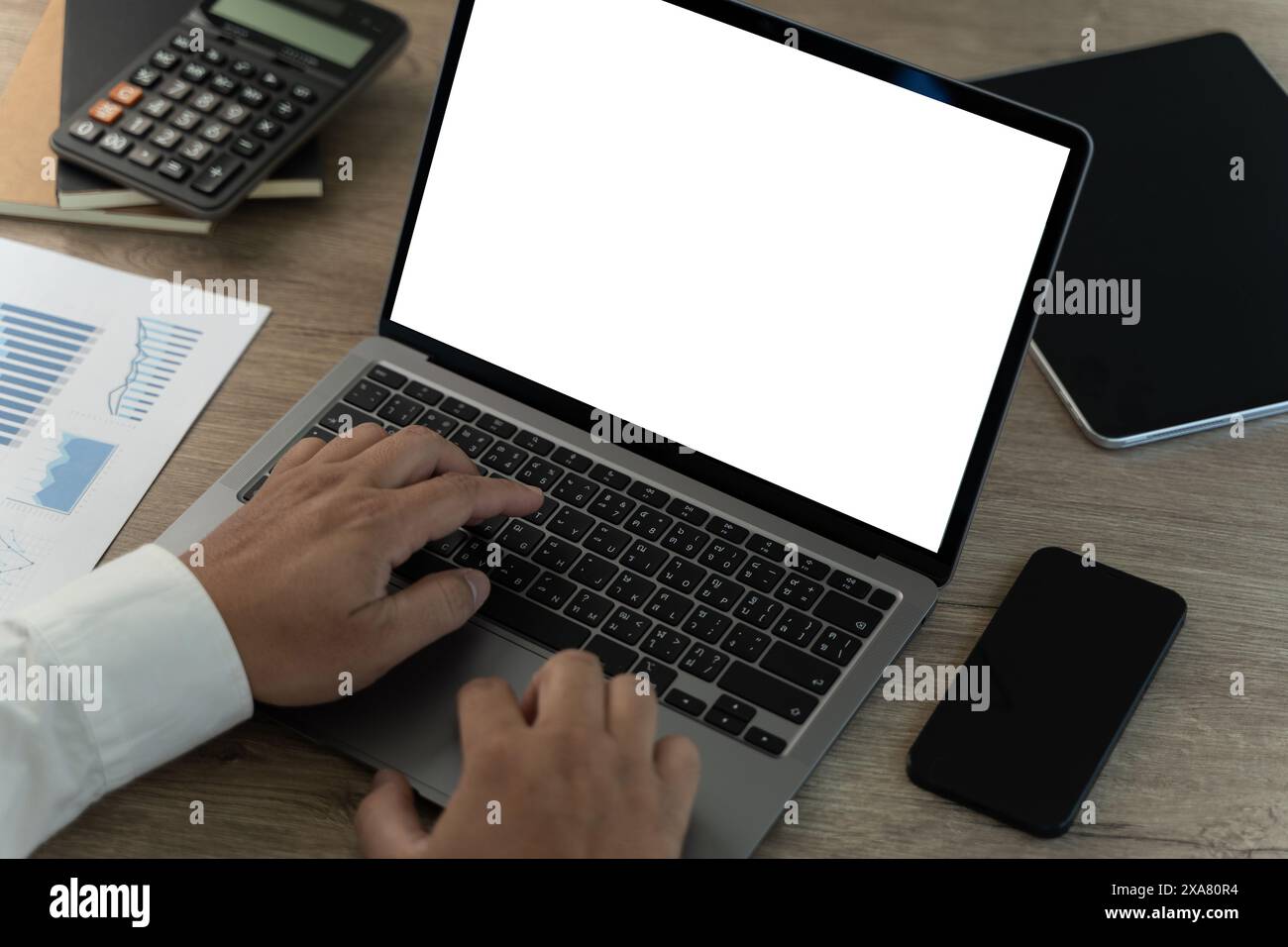 Primo piano di mani maschili e computer portatile con l'uso di una stanza d'ufficio con schermo vuoto e spazio di copia Vista ravvicinata dello schermo mock-up Foto Stock