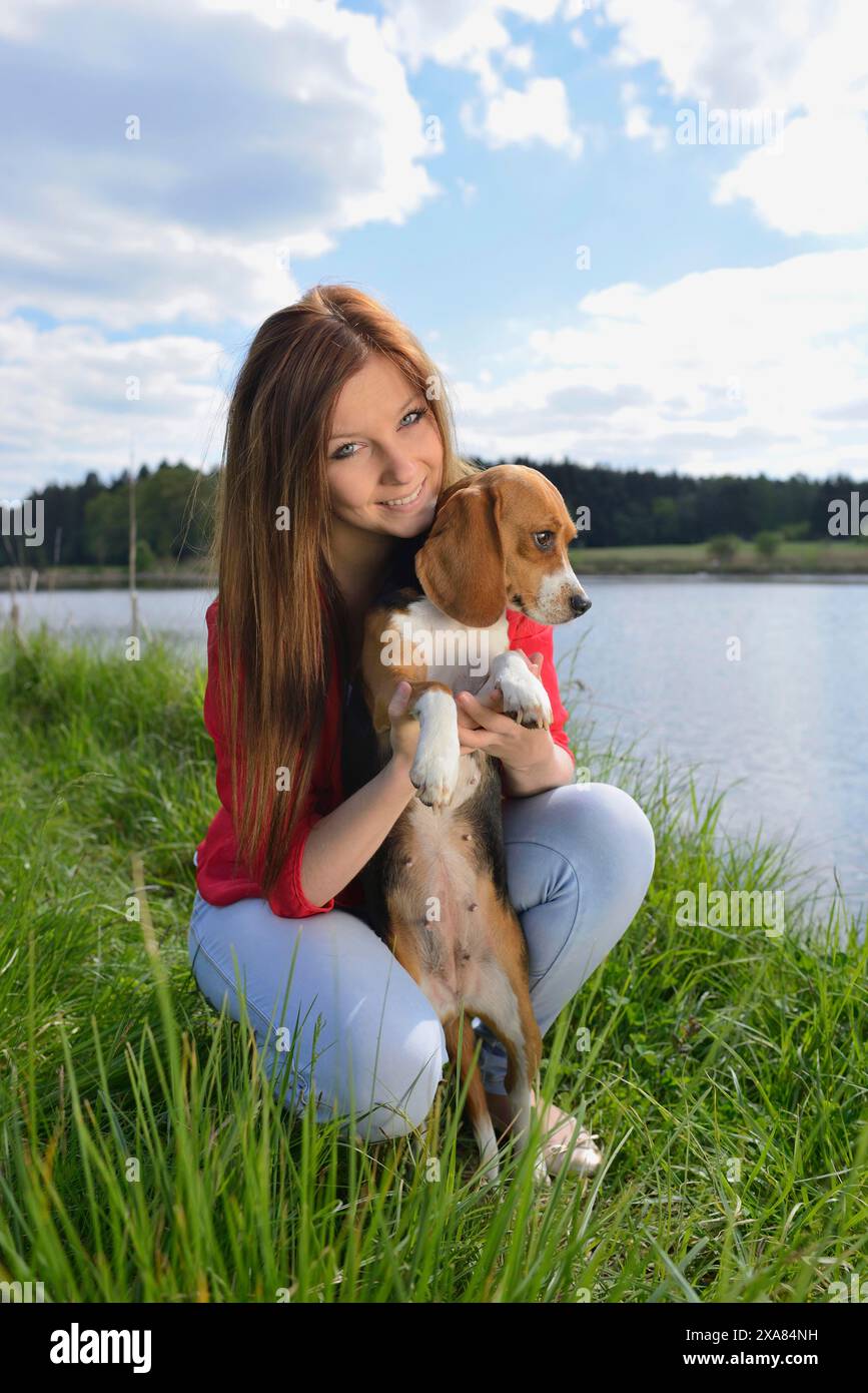 Primo piano di una giovane donna con il suo cane Beagle in primavera Foto Stock