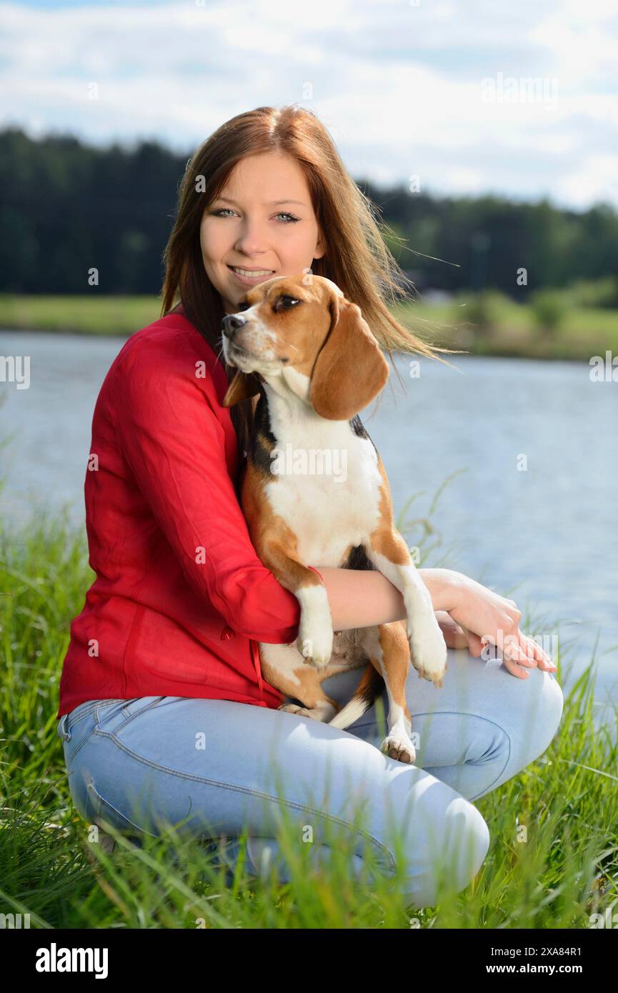 Primo piano di una giovane donna con il suo cane Beagle in primavera Foto Stock