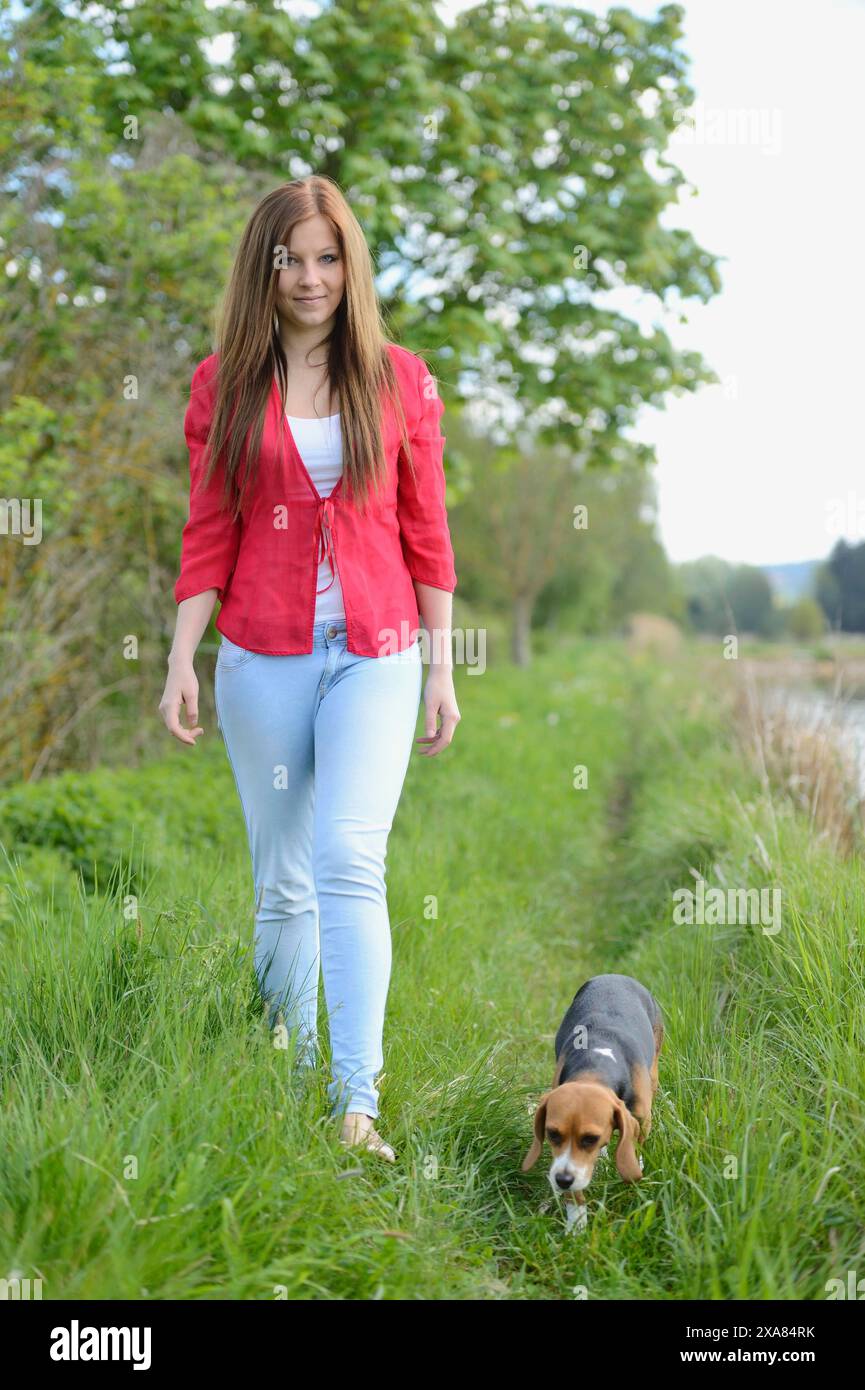 Primo piano di una giovane donna con il suo cane Beagle in primavera Foto Stock