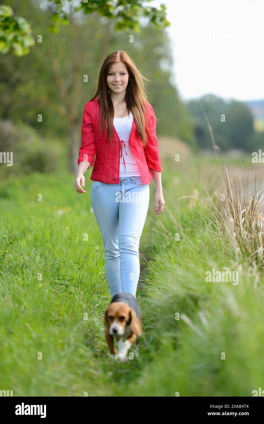 Primo piano di una giovane donna con il suo cane Beagle in primavera Foto Stock