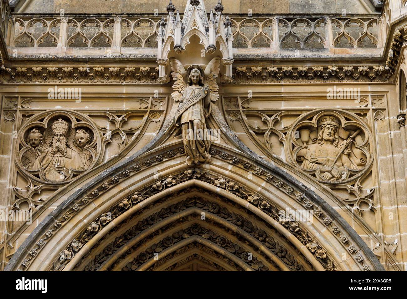 Un primo piano dell'intricata muratura in pietra sopra l'ingresso della Cappella reale di Dreux, Francia, con un angelo con le ali allungate e due fichi Foto Stock