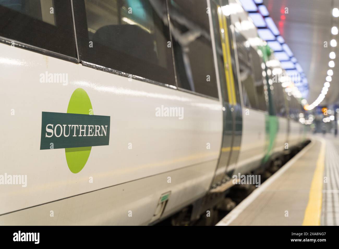 Logo della Southern Railway stampato sul pannello laterale del carrello visto dalla piattaforma con faretti accesi sul tetto della piattaforma London Bridge UK Foto Stock