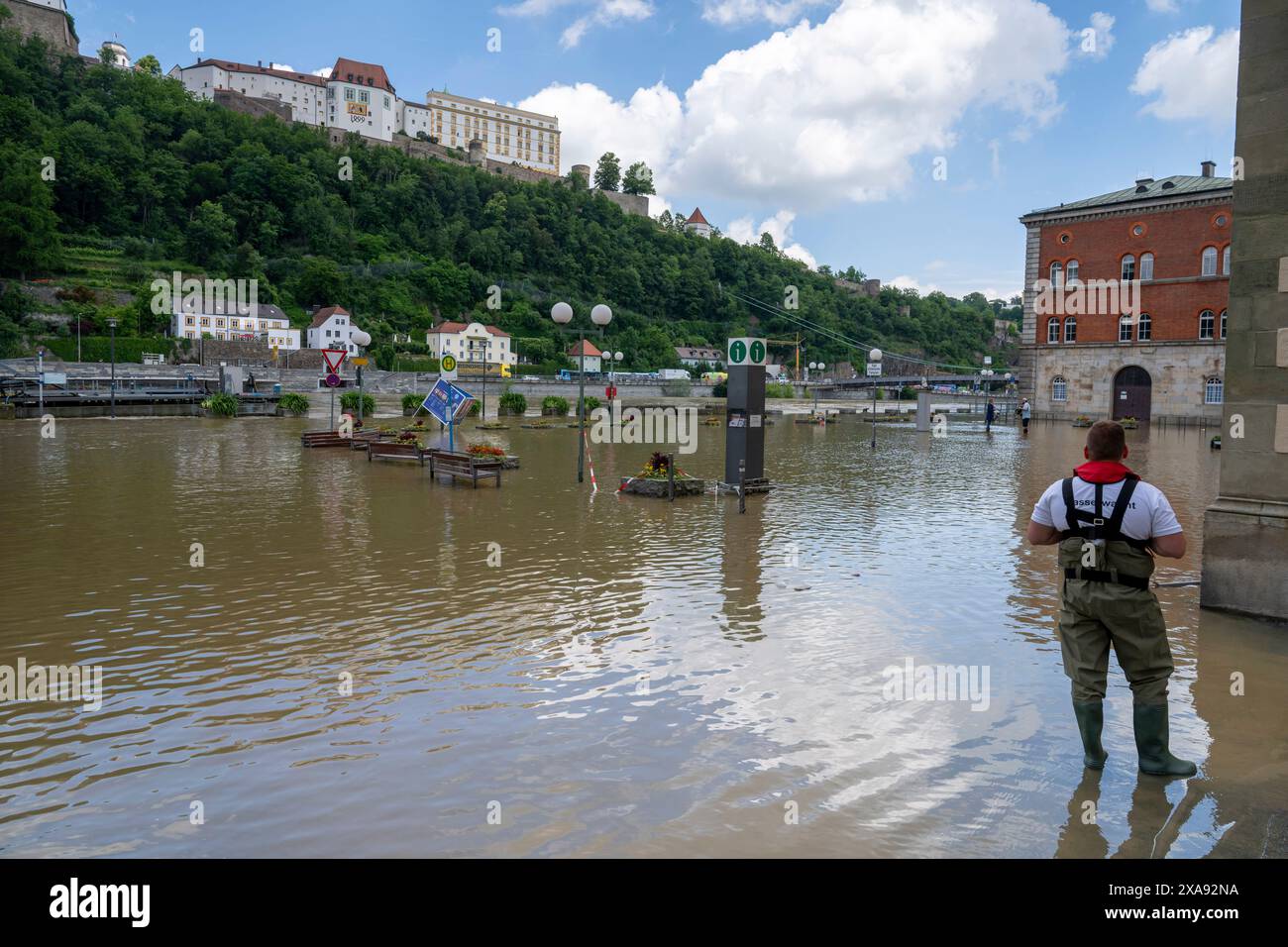 5 giugno 2024, Baviera, Passau: Un uomo del servizio di soccorso idrico si trova ai margini di una strada allagata della città sui tre fiumi. Molti luoghi della Baviera sono ancora allagati dopo forti piogge. Foto: Peter Kneffel/dpa Foto Stock