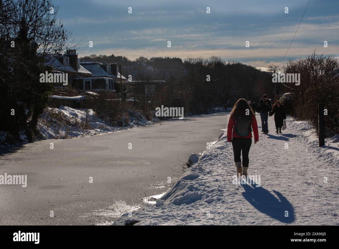 Edimburgo, Scozia; 02-11-2021: Persone che camminano lungo il Canale dell'Unione in una giornata invernale di sole, con neve a terra e acqua ghiacciata nel canale Foto Stock