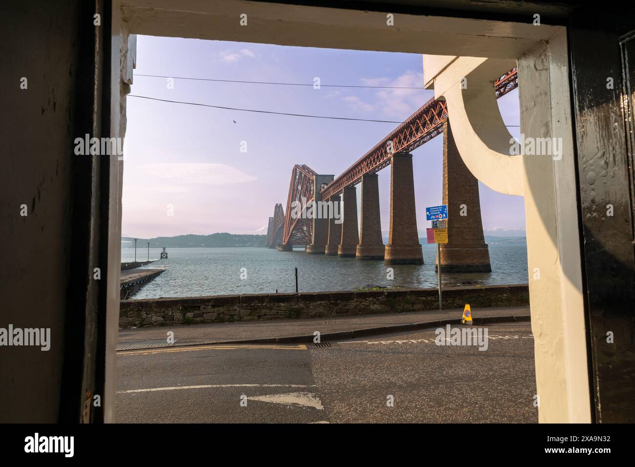 L'iconico Forth Bridge, un ponte ferroviario a sbalzo, è visto da un pub a sud di Queensferry. Completato nel 1890, è un sito patrimonio dell'umanità dell'UNESCO. Foto Stock