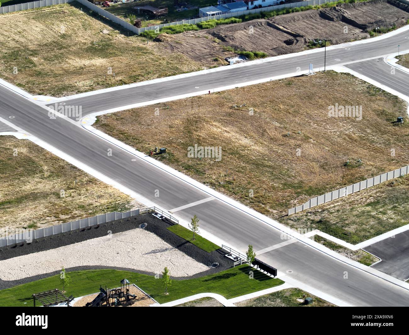 Un piccolo incrocio cittadino con strade ed erba Foto Stock