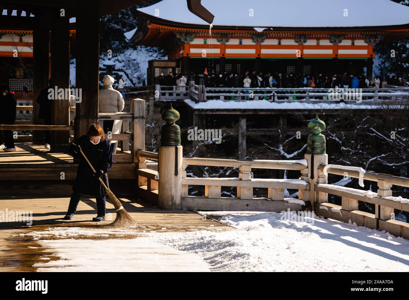 Una donna giapponese che spazza via dalla piattaforma coperta di neve nell'antico complesso sacro del tempio buddista Kiyomizudera a Kyoto, in Giappone Foto Stock