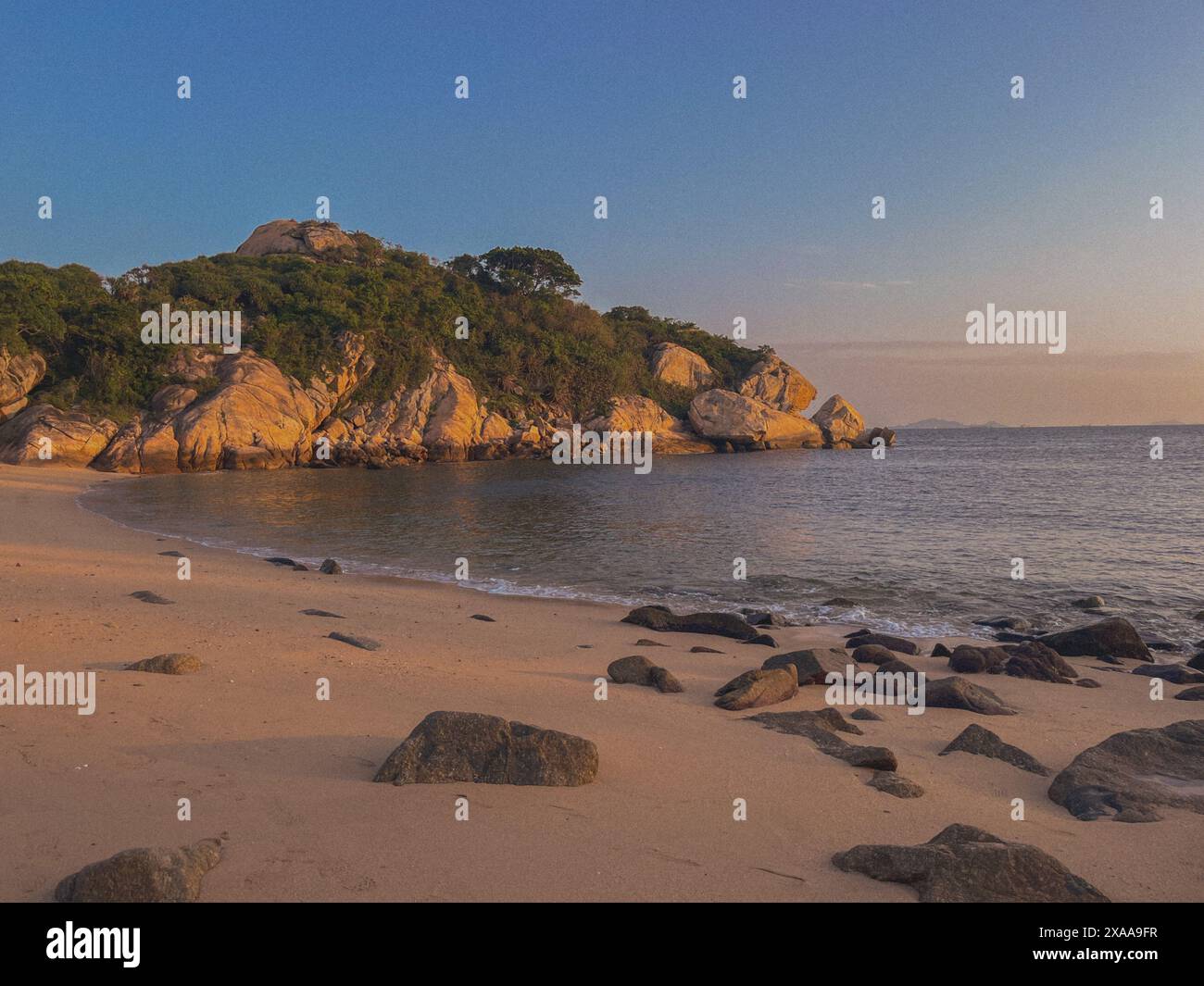 Una spiaggia deserta all'alba con rocce e sabbia a Cheung Chau, Hong Kong Foto Stock