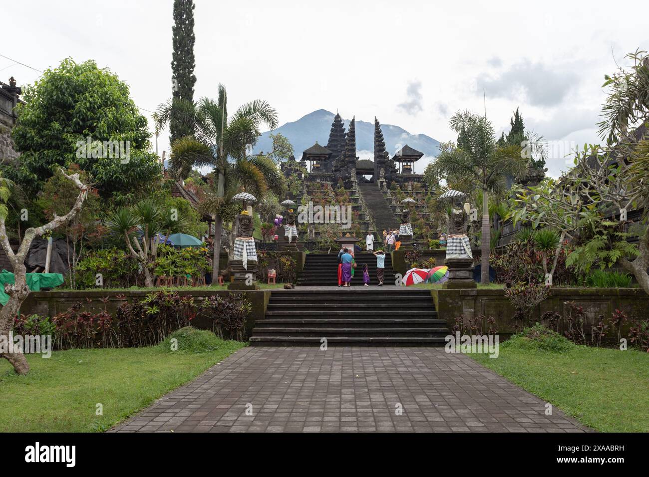 Un gruppo di persone sedute sulle scale di fronte a una pagoda tradizionale Foto Stock