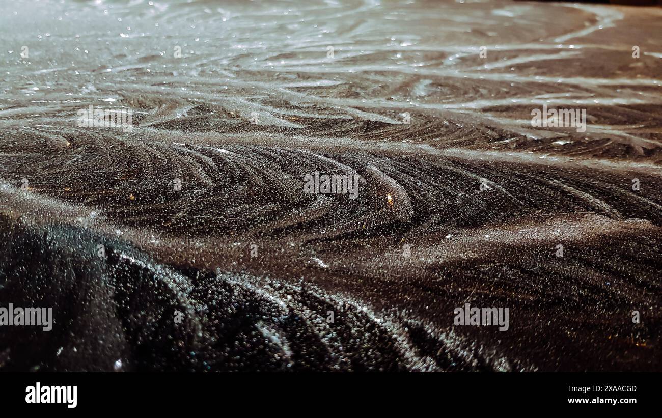 Un primo piano di rocce umide sulla spiaggia di notte Foto Stock