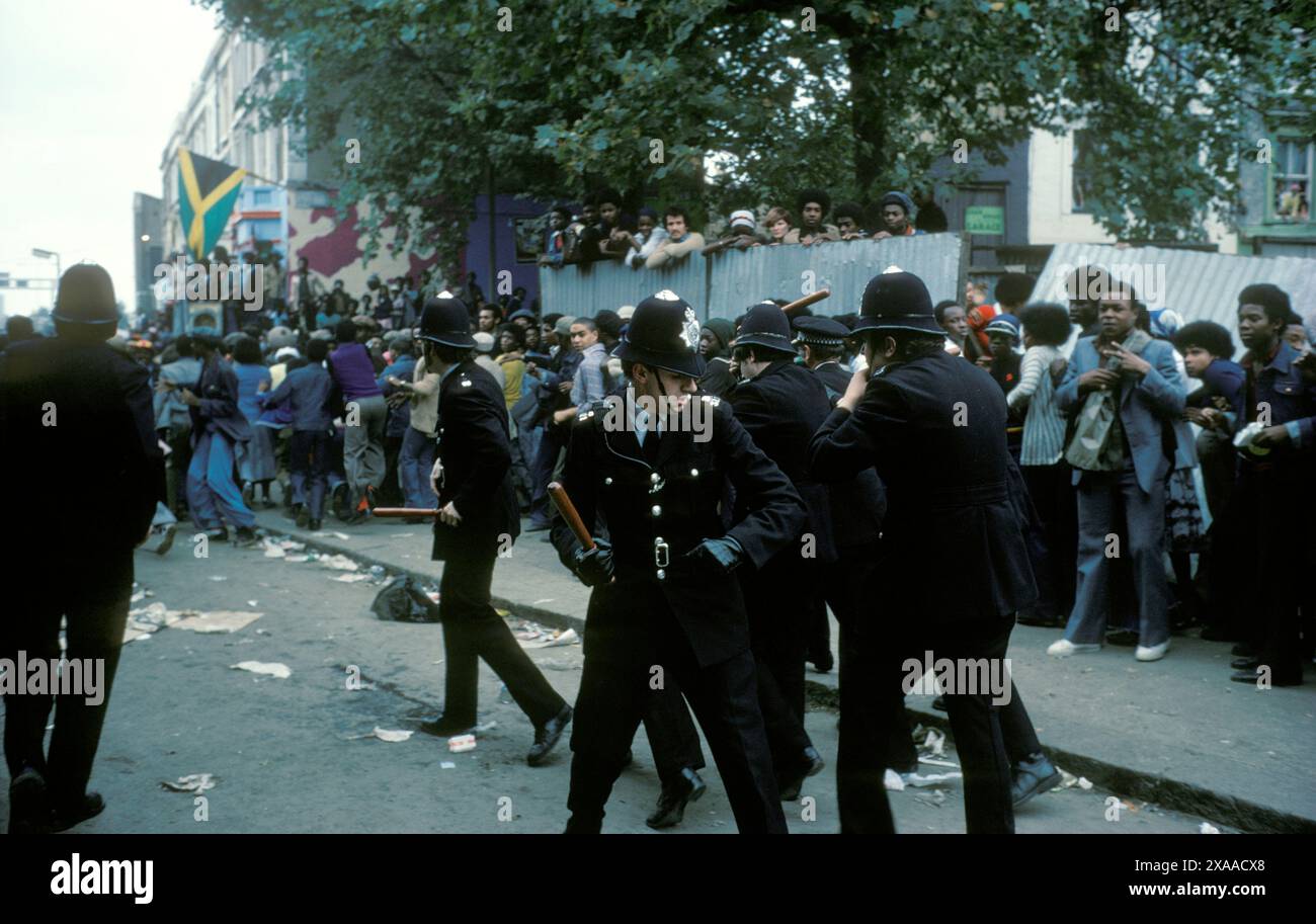 La rivolta del carnevale di Notting Hill agosto festivi lunedì 1976. La polizia viene attaccata da giovani britannici di colore. I perni disegnati, si raggruppano per autoprotezione. Non hanno scudi o indumenti protettivi. Notting Hill, Londra, Inghilterra 30 agosto. 1970 UK HOMER SYKES Foto Stock