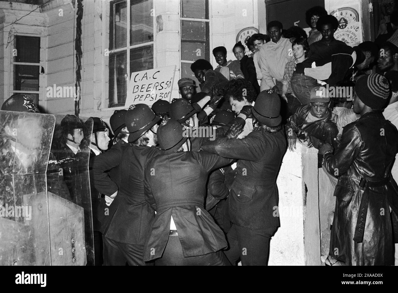 La rivolta del carnevale di Notting Hill agosto festivi lunedì 1976. La polizia irrompe in una casa privata a All Saints Road durante le rivolte del Carnevale di Notting Hill. Notting Hill, Londra, Inghilterra, agosto 1979. Anni '1970 Regno Unito. HOMER SYKES Foto Stock