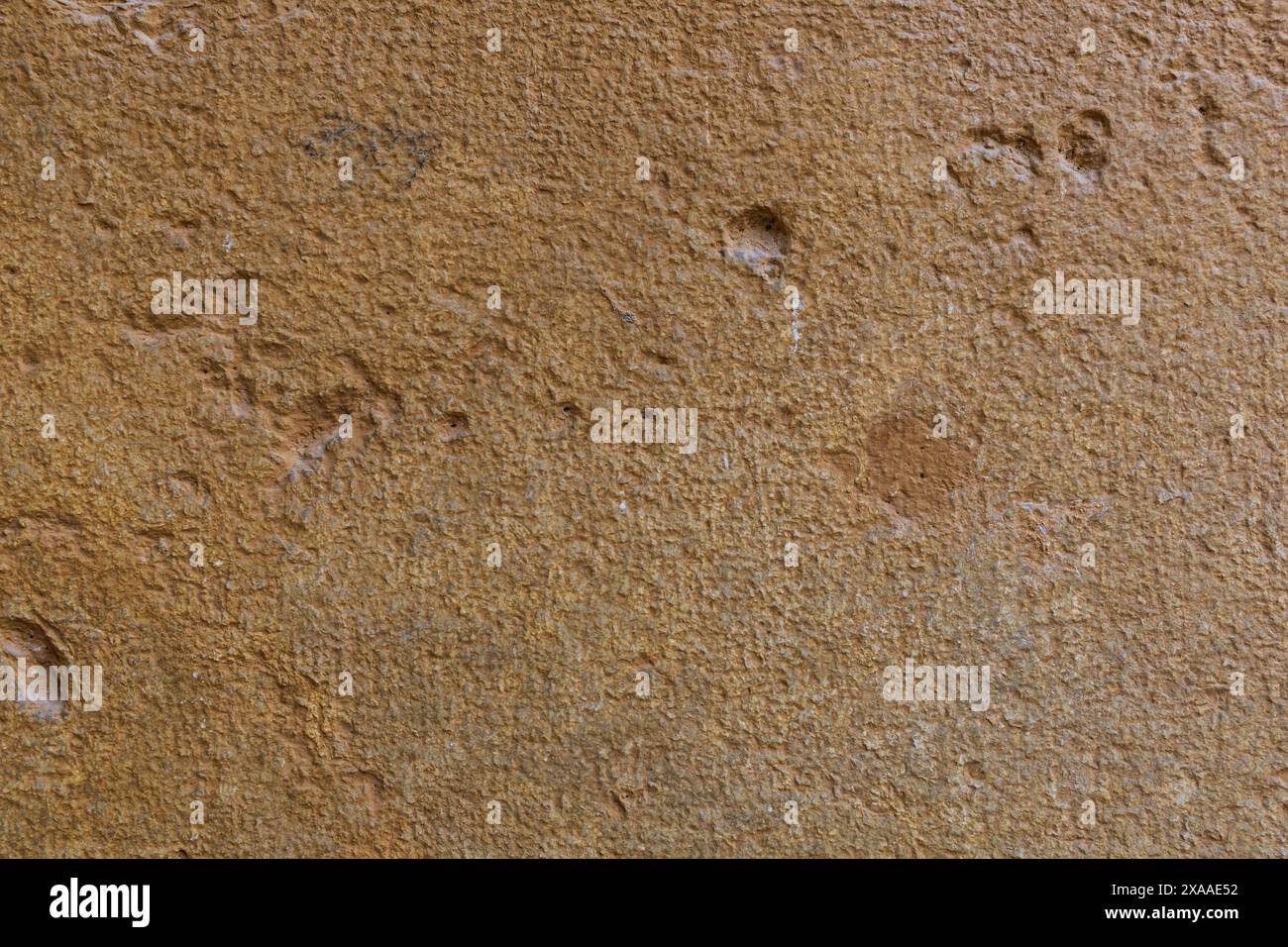 foto in primo piano di un'antica struttura in pietra di un muro di colore terracotta chiaro Foto Stock