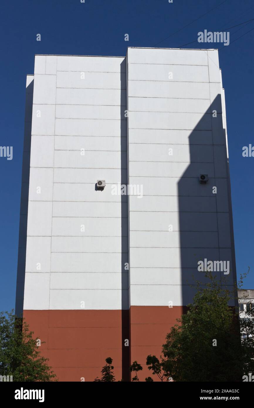 Architettura minimalista. Parete bianca di un'alta casa di appartamenti alla luce del sole Foto Stock