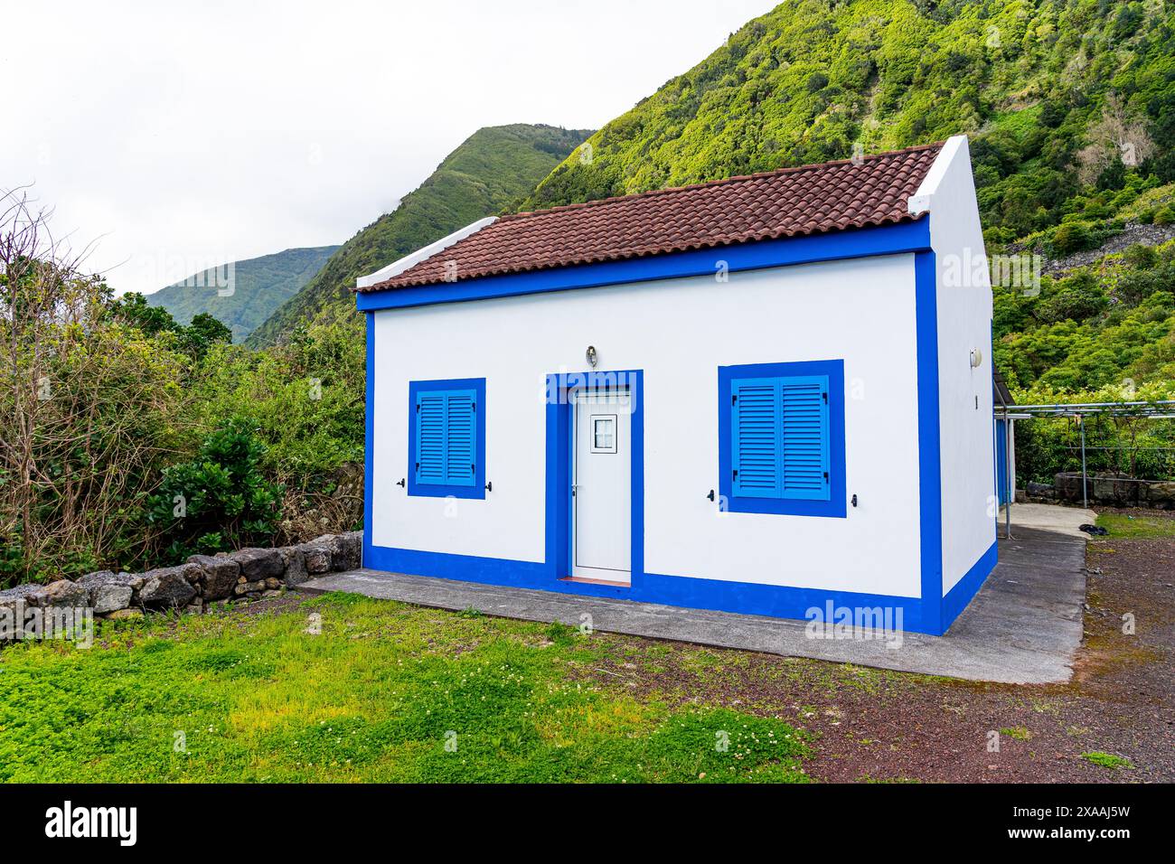 Bella casa bianca con telai blu delle porte e finestre tipiche di Fajã dos Cavales. Isola di São Jorge-Azzorre-Portogallo Foto Stock