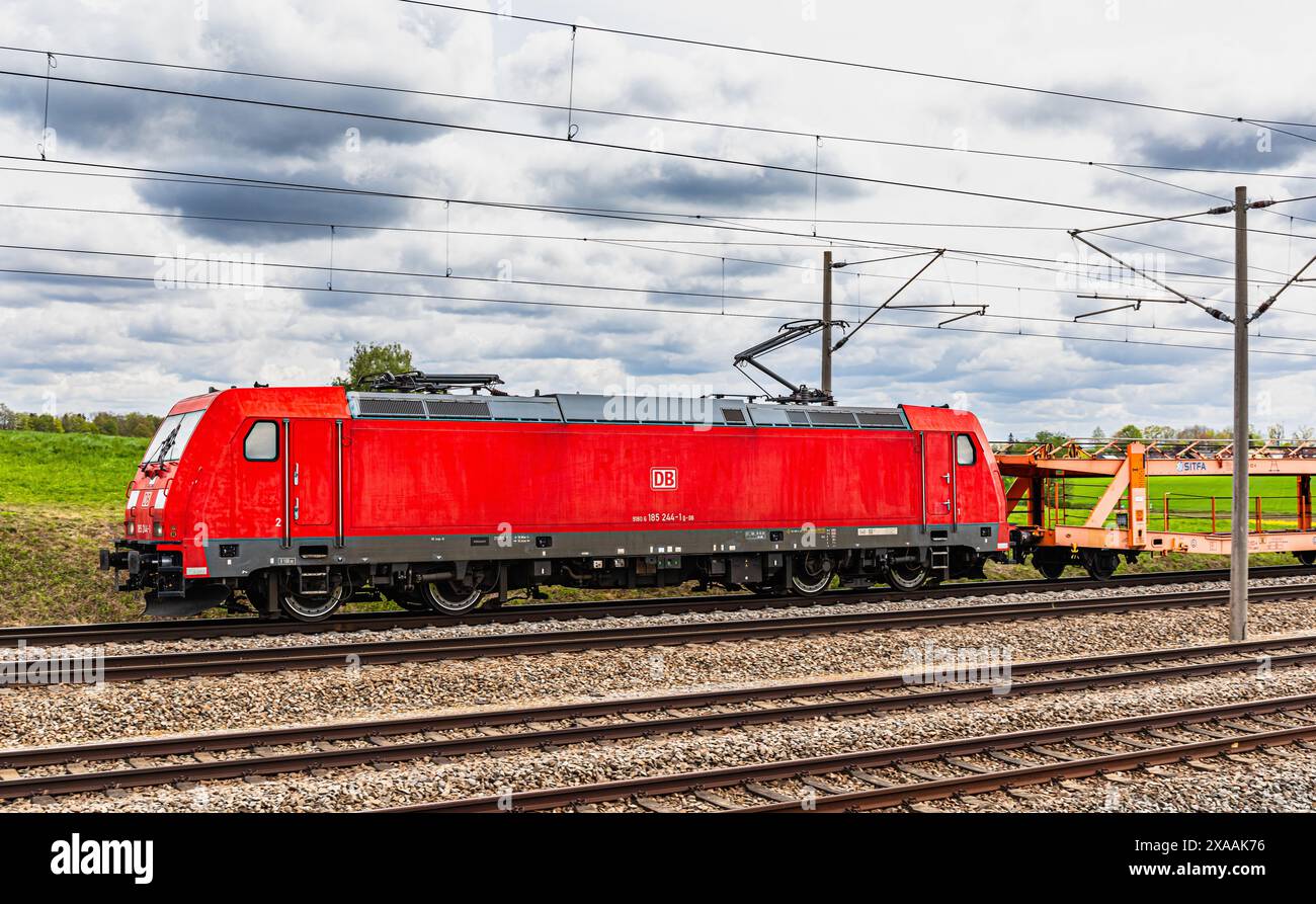 Hebertshausen, Germania, 10 aprile 2024: Una locomotiva elettrica della Deutsche Bahn (DB classe 185) tira un treno merci. (Foto di Jonas Philippe/dieB Foto Stock