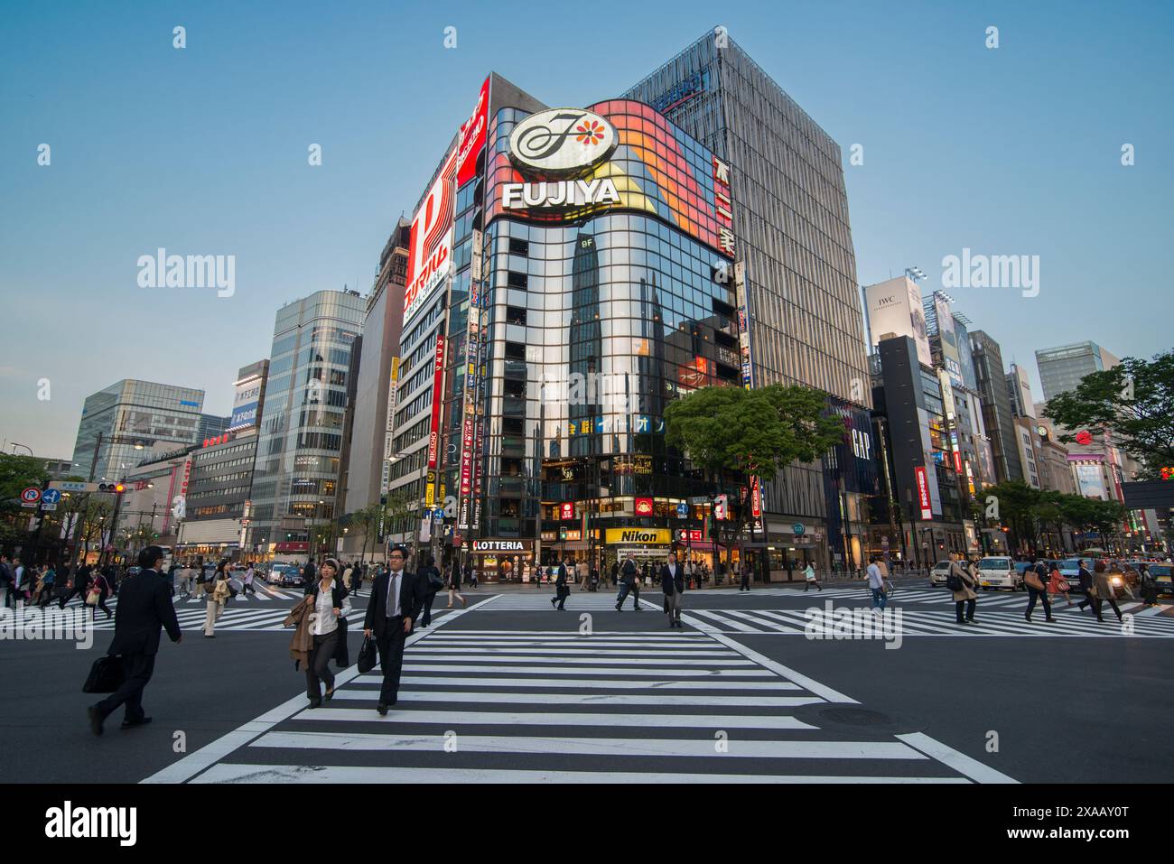 Attraversamento di fronte ai moderni centri commerciali di Ginza, Tokyo, Honshu, Giappone, Asia Foto Stock