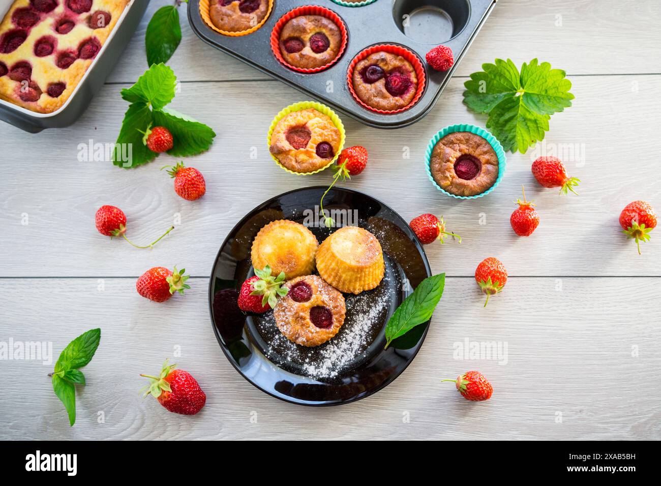 Muffin dolci con ripieno di fragole, in un piatto su un tavolo di legno. Foto Stock