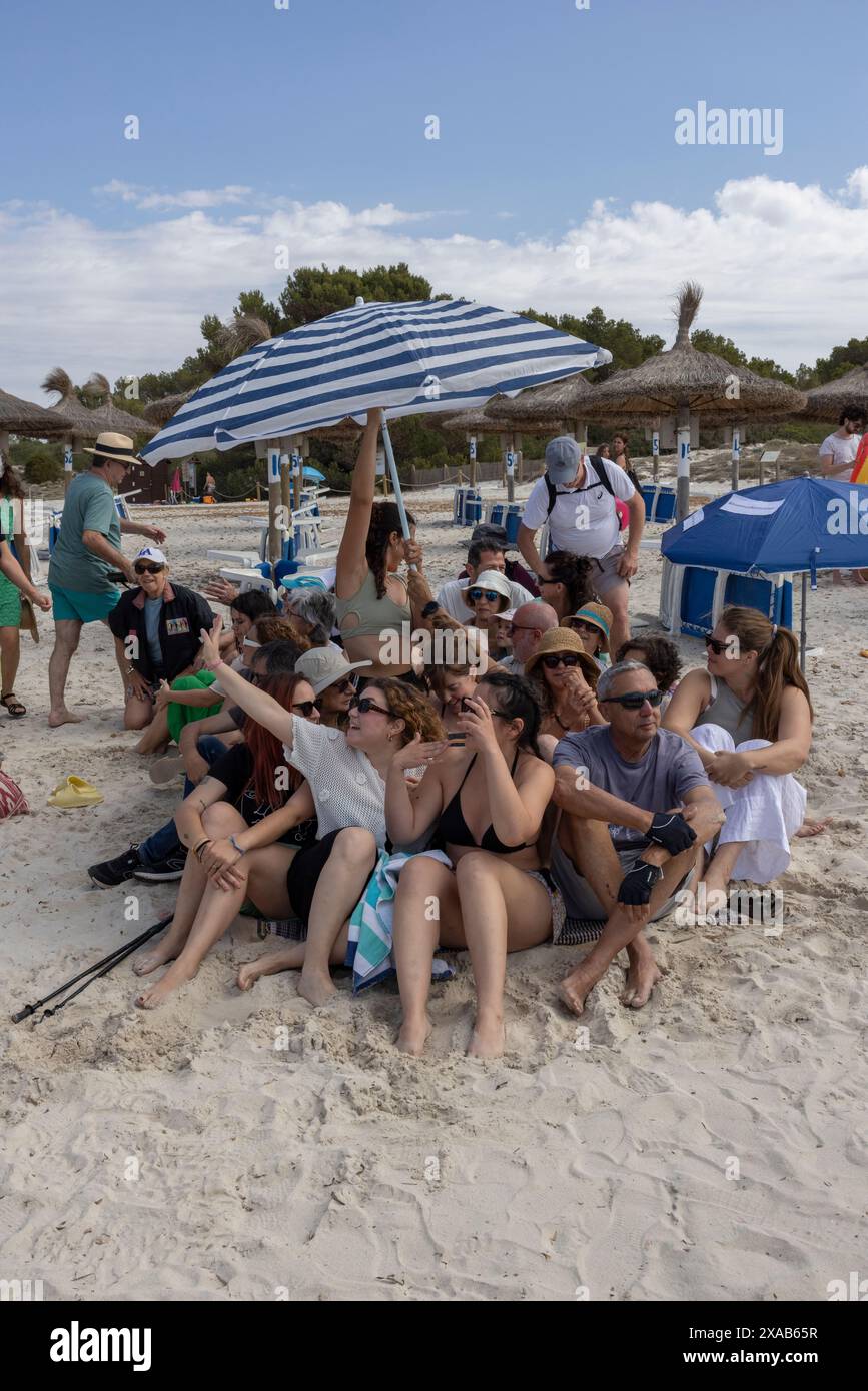I manifestanti spagnoli alla spiaggia di sa Rapita simulano uno scenario di spiaggia ricco per enfatizzare il sovraffollamento delle spiagge dovuto al turismo eccessivo a Maiorca. Foto Stock