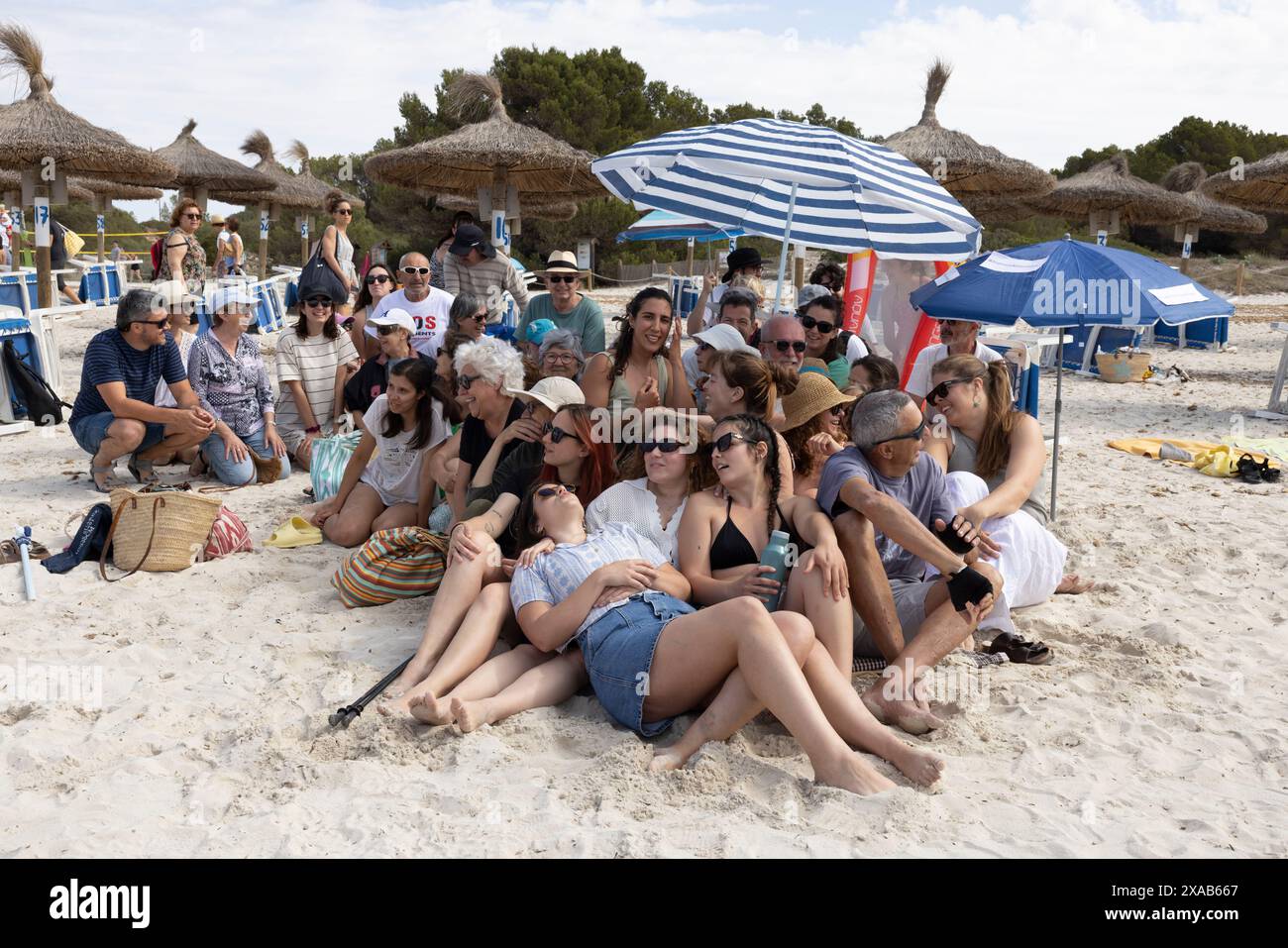 I manifestanti spagnoli alla spiaggia di sa Rapita simulano uno scenario di spiaggia ricco per enfatizzare il sovraffollamento delle spiagge dovuto al turismo eccessivo a Maiorca. Foto Stock