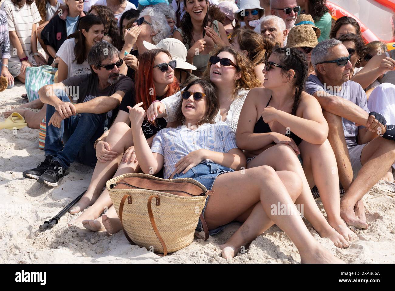 I manifestanti spagnoli alla spiaggia di sa Rapita simulano uno scenario di spiaggia ricco per enfatizzare il sovraffollamento delle spiagge dovuto al turismo eccessivo a Maiorca. Foto Stock