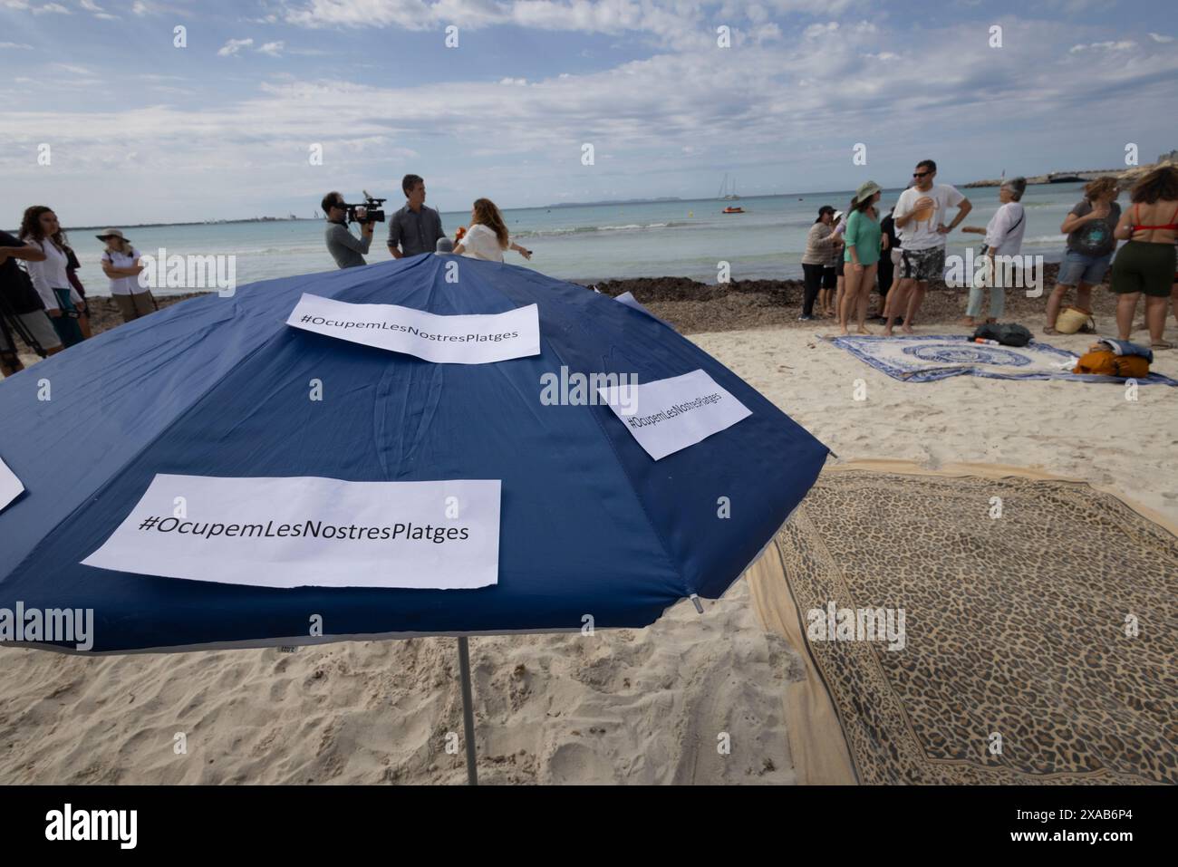 I manifestanti spagnoli alla spiaggia di sa Rapita simulano uno scenario di spiaggia ricco per enfatizzare il sovraffollamento delle spiagge dovuto al turismo eccessivo a Maiorca. Foto Stock