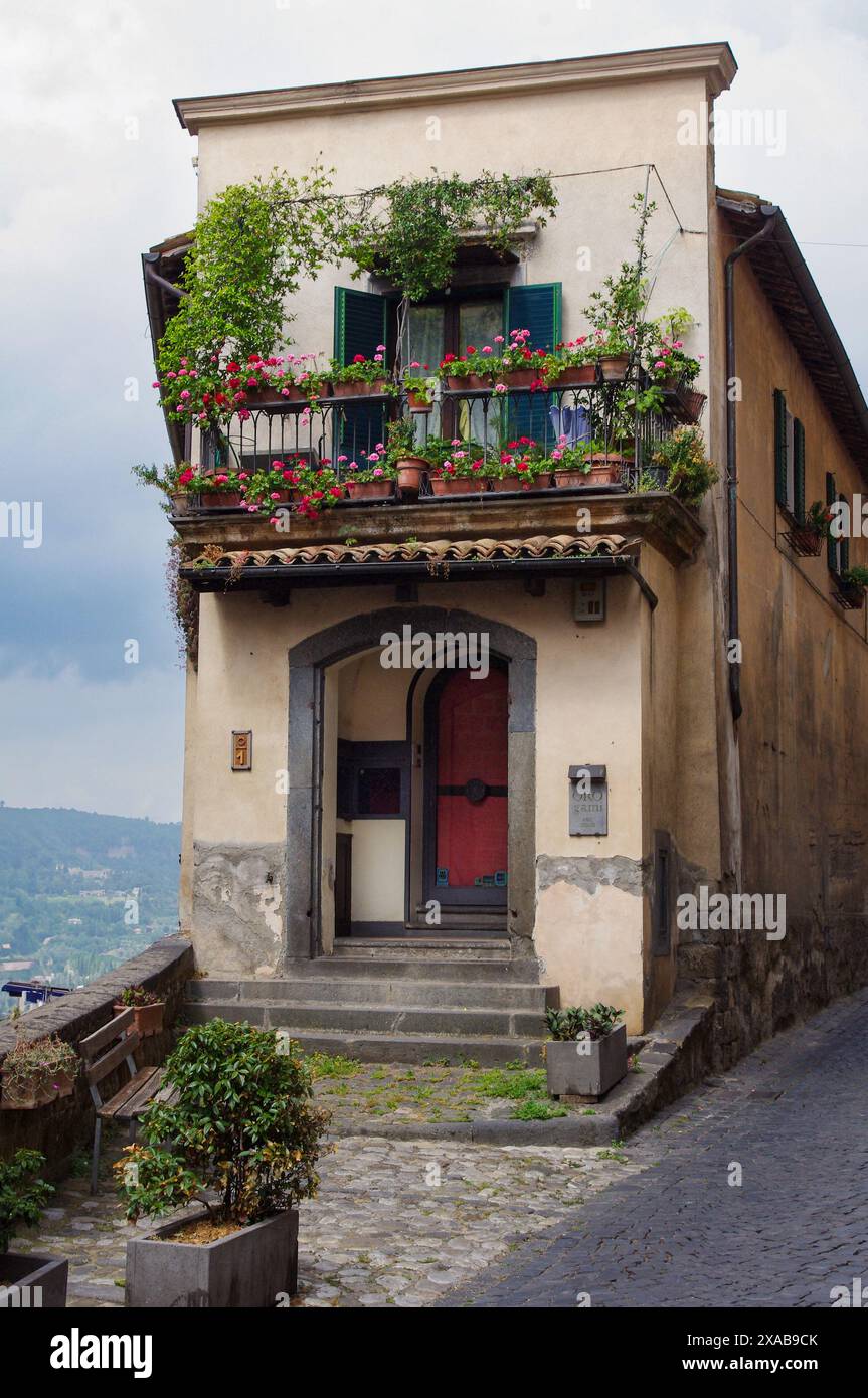 Casa di Orvieto con giardini al piano superiore con container/finestra e porta rossa, Orvieto, Italia Foto Stock