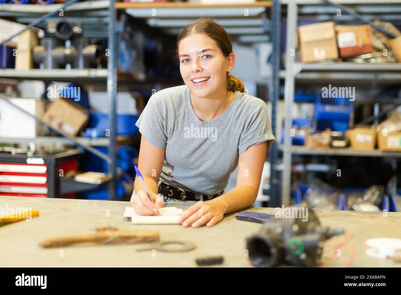 Il lavoratore del magazzino del negozio prende appunti nel notebook, tiene traccia delle merci Foto Stock