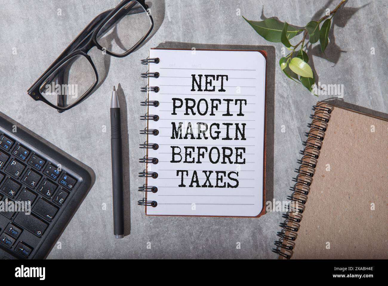 Text NET PROFIT MARGIN BEFORE TAX on tablet display in businessman hands on the white background. Concetto di business Foto Stock