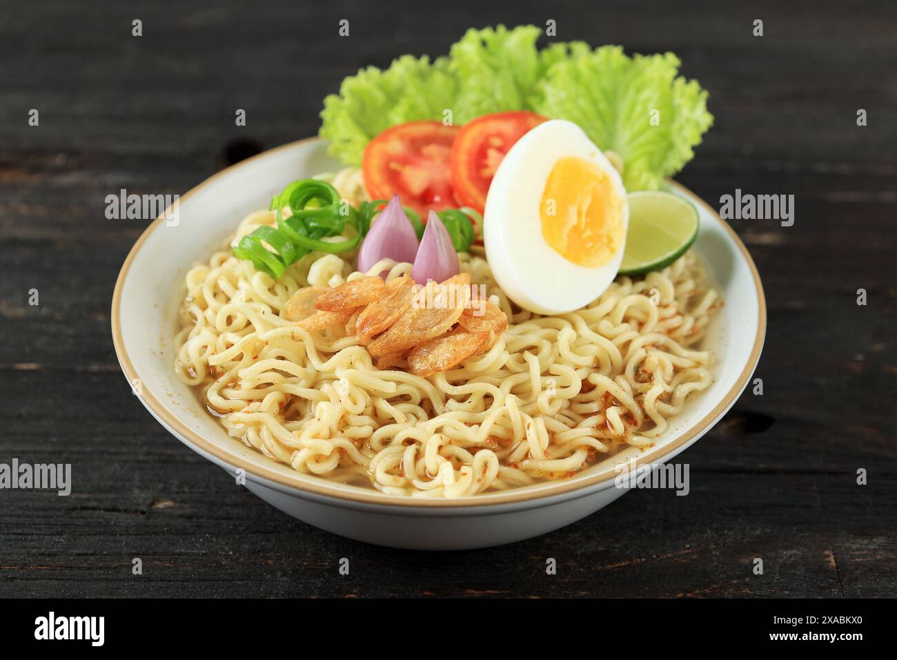 Primo piano: Tagliatelle istantanee bollite o Indomie Rebus su ciotola in ceramica bianca Foto Stock