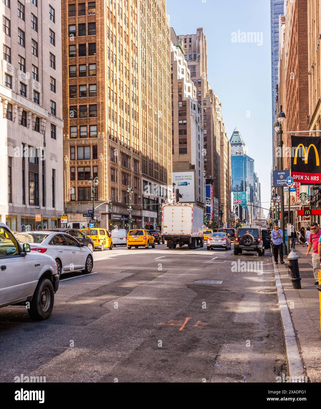 New York City, Stati Uniti - 24 agosto 2017: Vicino all'angolo tra Eighteenth Avenue e West 35th Street, con facciate di edifici, automobili e persone. Foto Stock