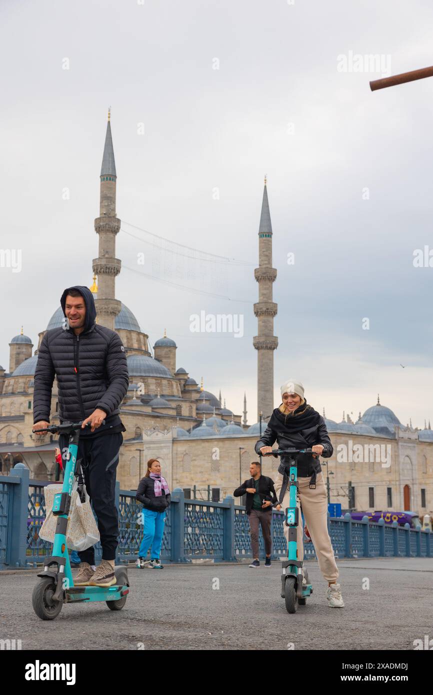 La coppia si diverte con gli e-scooter noleggiabili a Istanbul. Foto del concetto di mobilità micro in Turchia. Istanbul, Turkiye - 3.31.2023 Foto Stock