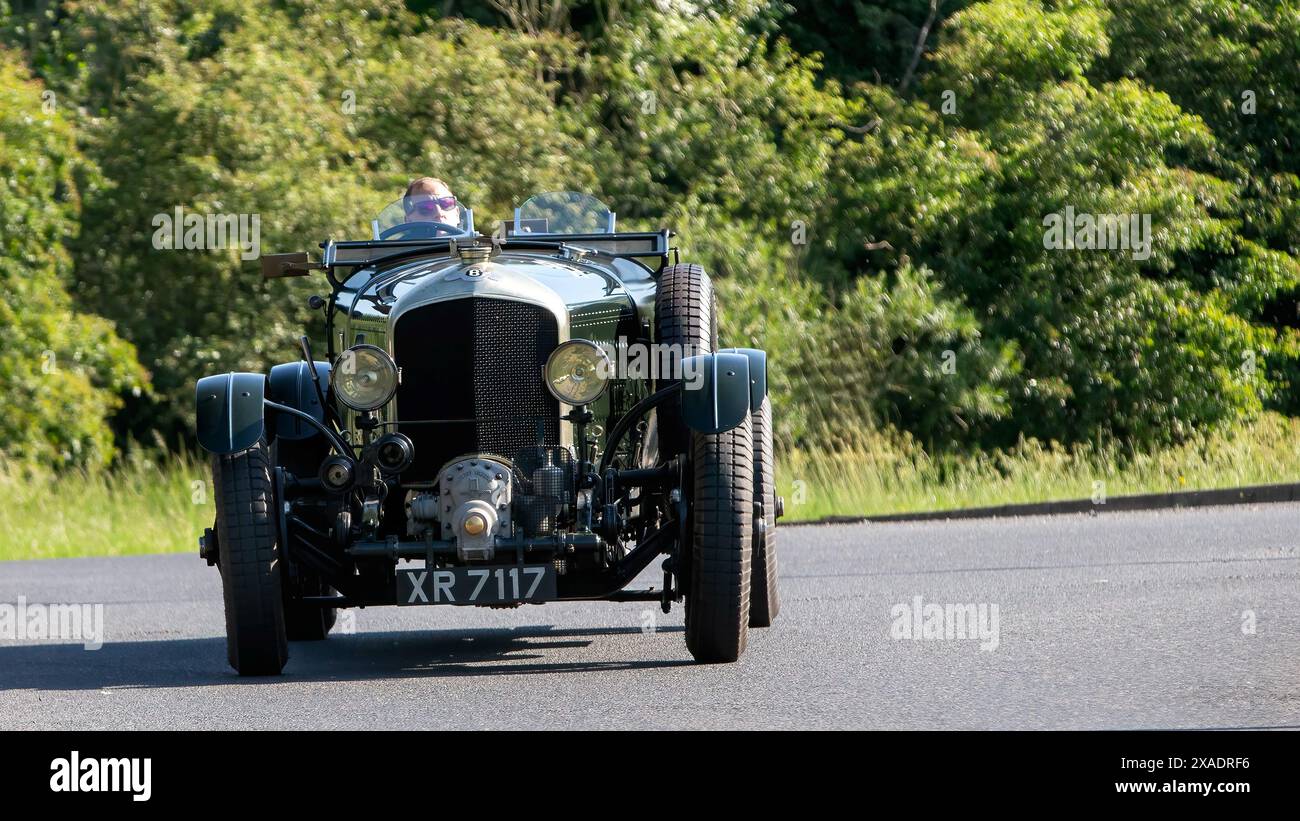 Stony Stratford, Regno Unito - 2 giugno 2024: 1924 auto d'epoca Bentley verde che guida su una strada di campagna britannica Foto Stock