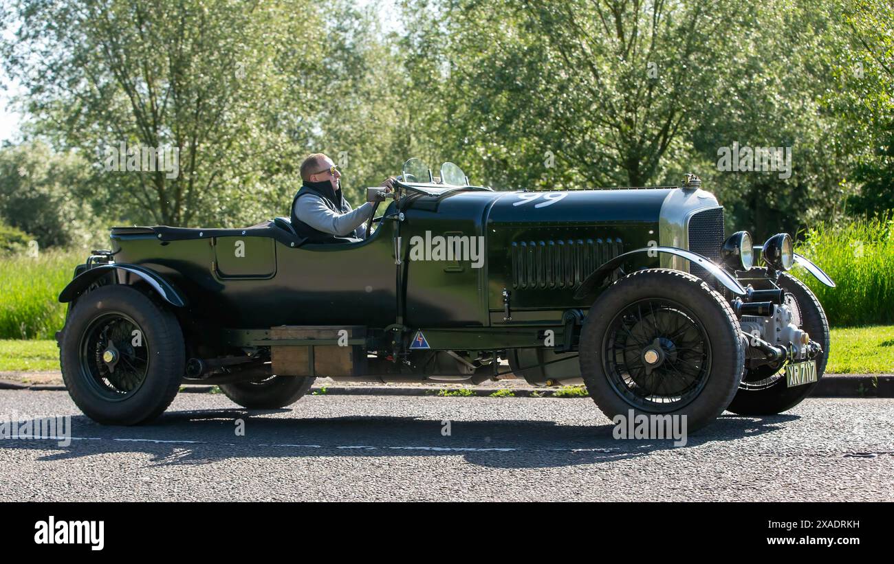 Stony Stratford, Regno Unito - 2 giugno 2024: 1924 auto d'epoca Bentley verde che guida su una strada di campagna britannica Foto Stock