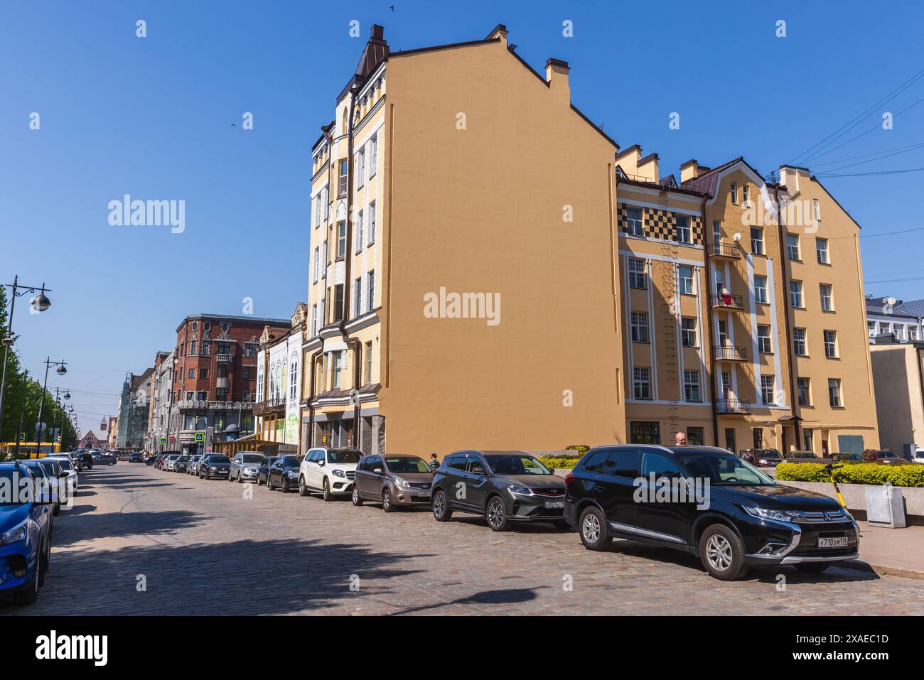 Vyborg, Russia - 27 maggio 2024: Lenin avenue in una giornata di sole, vista panoramica della strada con auto parcheggiate e persone che camminano Foto Stock