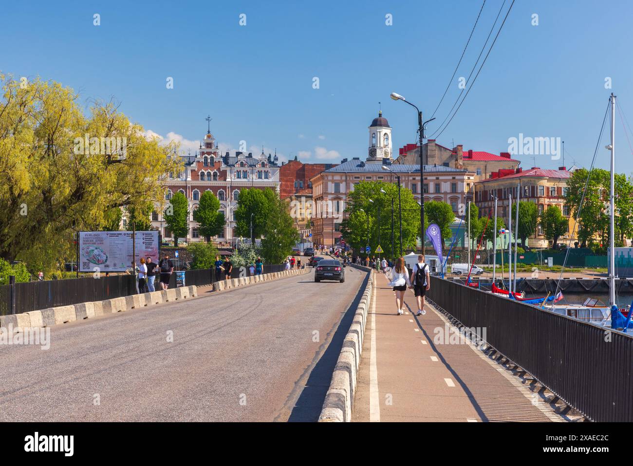 Vyborg, Russia - 27 maggio 2024: Vista sulla strada della città vecchia di Vyborg, la gente cammina sul Ponte della Fortezza in una soleggiata giornata estiva, vista prospettica Foto Stock