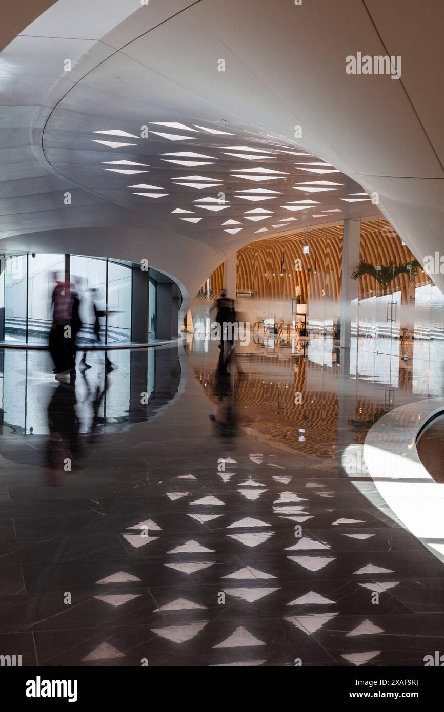 Un gruppo di persone in piedi nell'area ricevimento principale. BEEAH Headquarters, Sharjah, Emirati Arabi Uniti. Architetto: Zaha Hadid Architects, 2022. Foto Stock